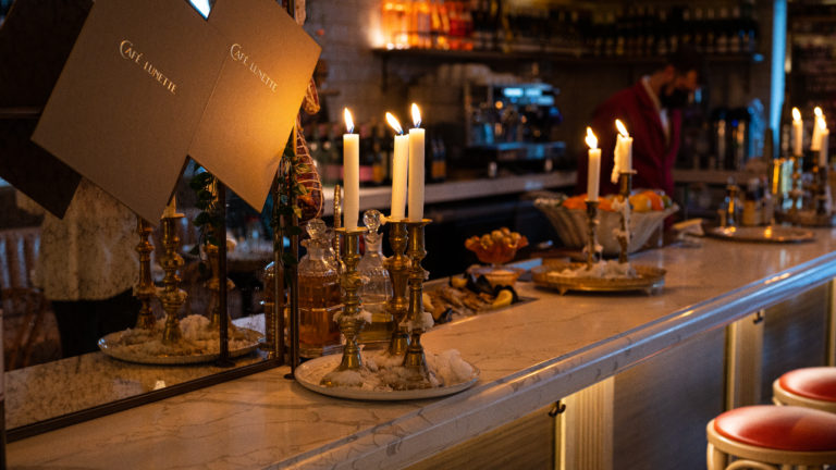 Lit candles sitting on the bar during the evening.